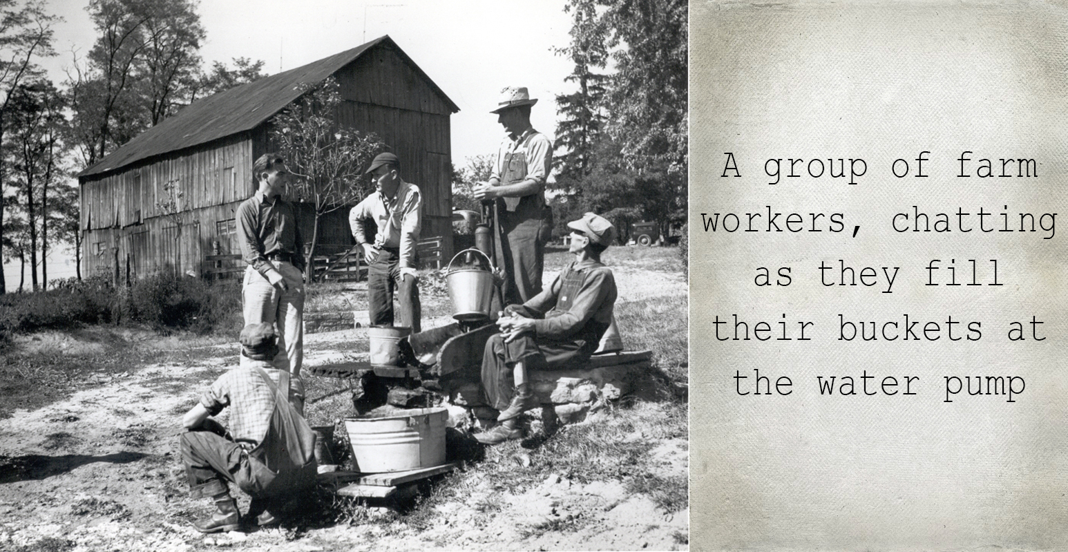 A group of farm workers, chatting as they fill their buckets at the water pump