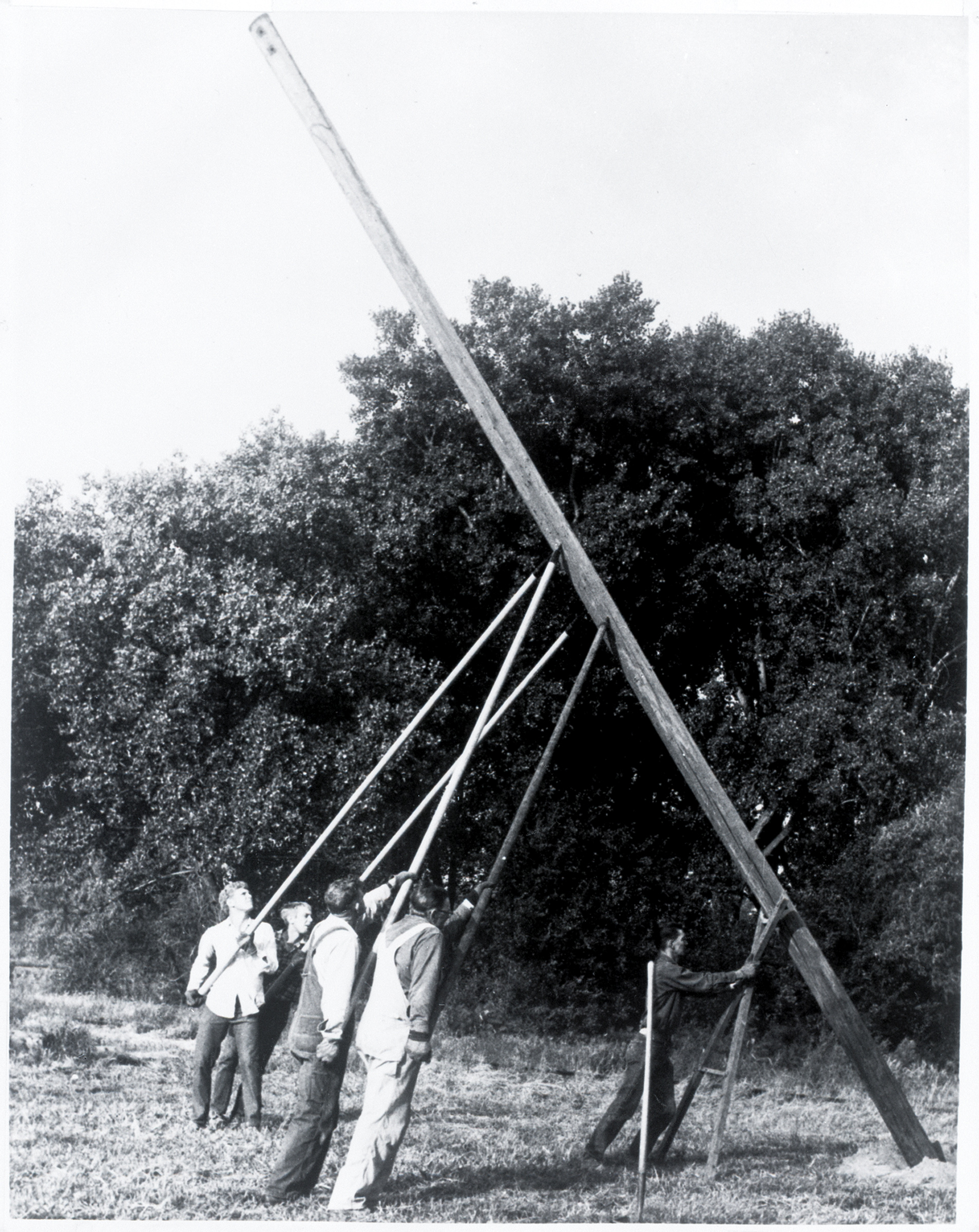 1930s lineworkers manually setting a pole