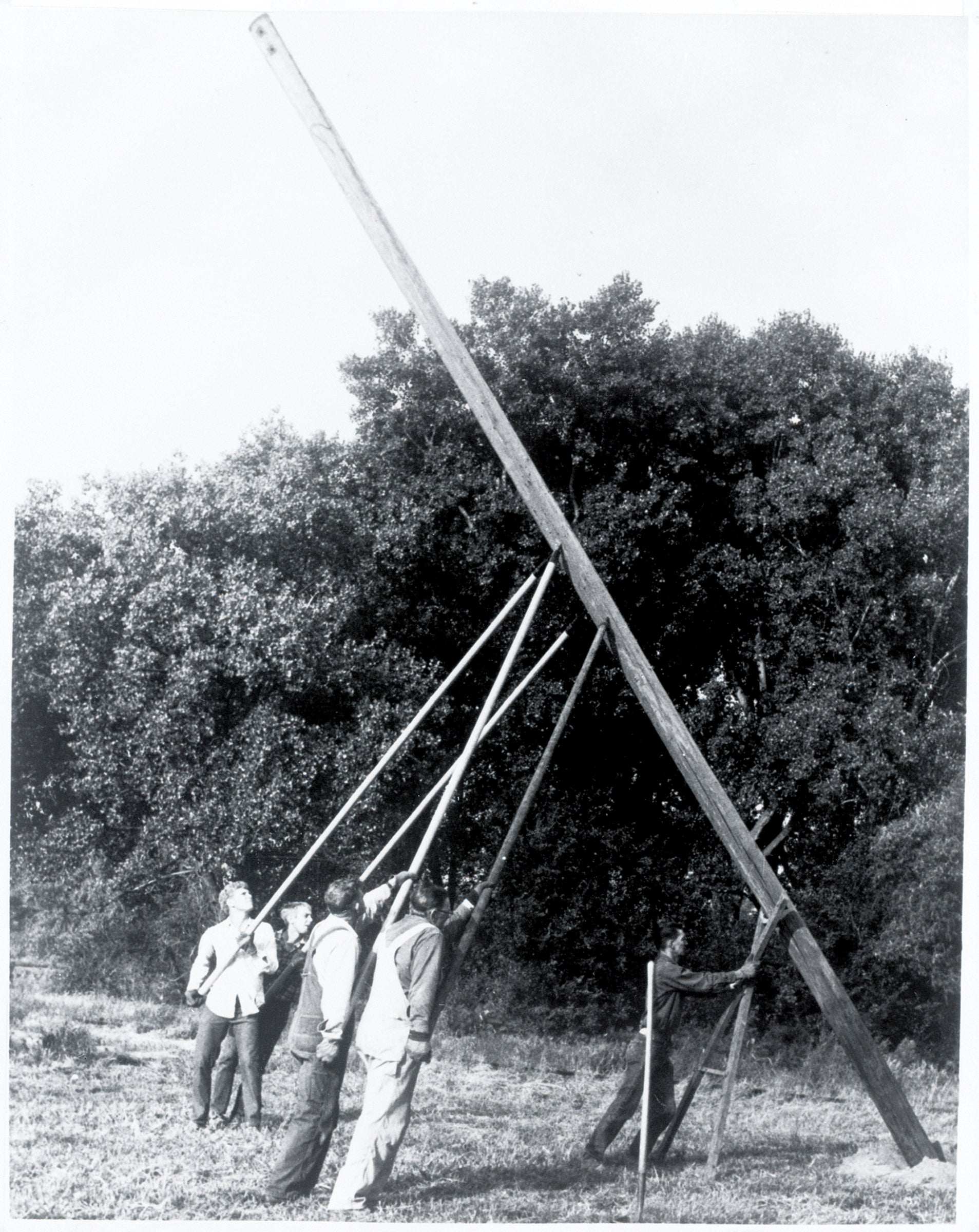 1930s lineworkers manually setting a pole