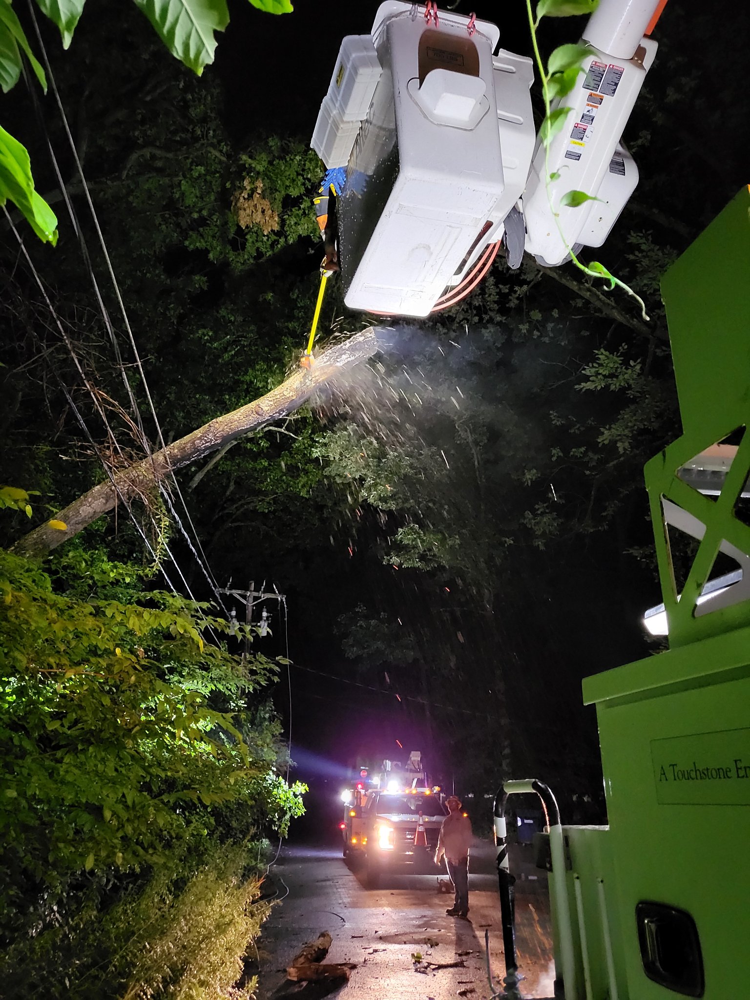 SREC crews work in darkness to remove a fallen tree from power lins on Up-A-Way Drive